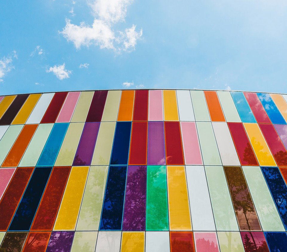looking up at a building covered in munti-coloured panels